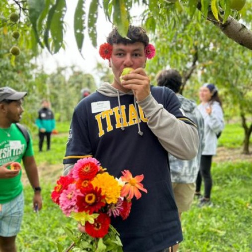Young man from Ithaca College Hillel enjooying apple and flower picking in the fall.