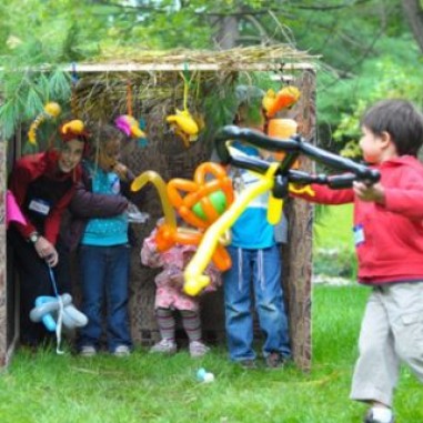 Young children playing in a mini sized sukkah