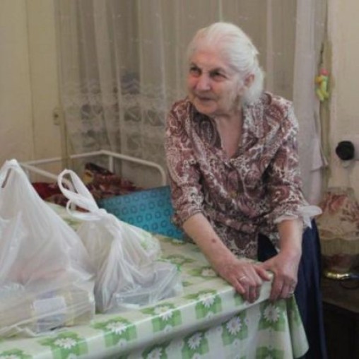 Older woman in Tbilisi with groceries on the table