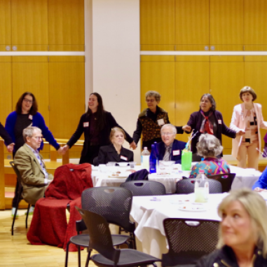 Adults dancing around dining tables