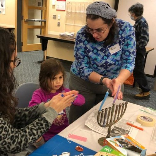 Adults and a child rolling wax candles