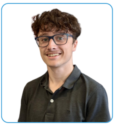 Head slightly tilted with a warm smile, wearing black glasses and shoulders angled left.