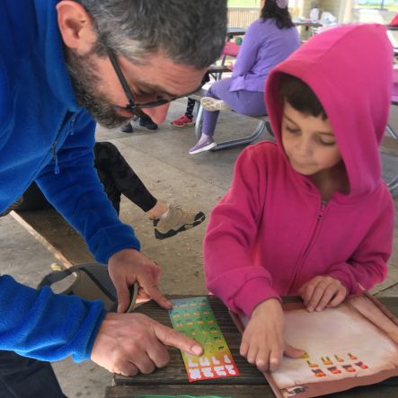 Father and child looking at Hebrew letters null