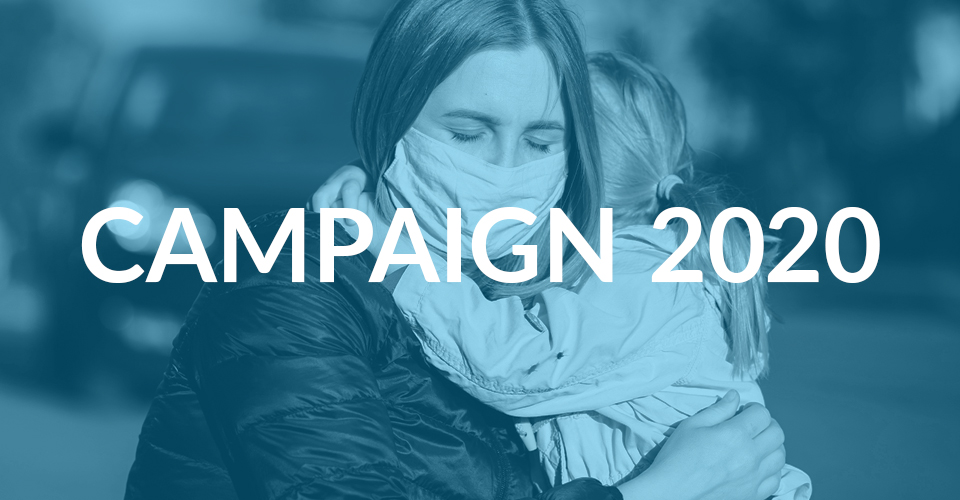 A mother wearing a mask, while holding a child