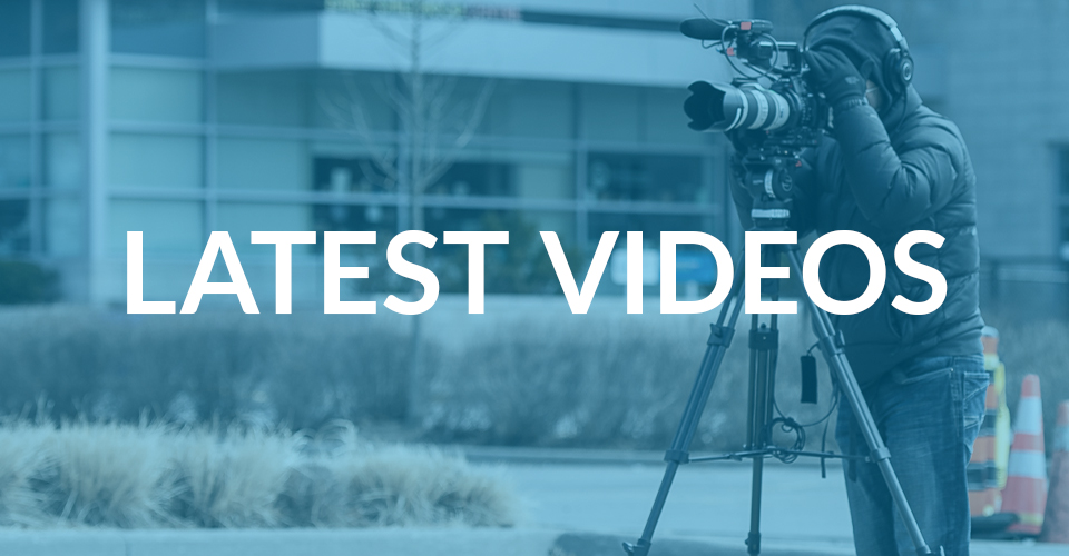 A person stading behind a video camera